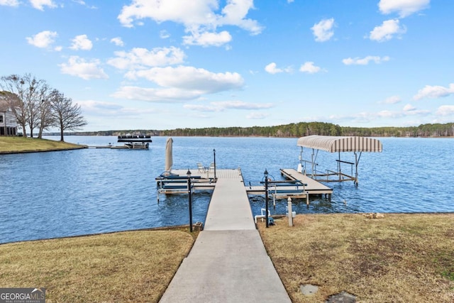 dock area featuring a water view, a yard, and boat lift