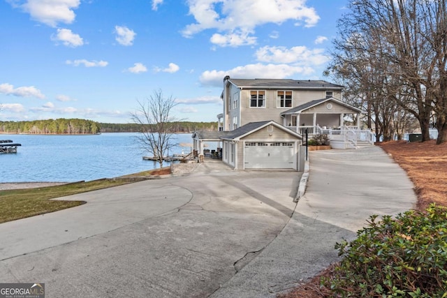 view of front of property featuring a water view, driveway, and a porch