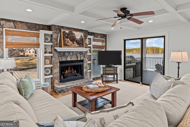 living area featuring recessed lighting, beam ceiling, coffered ceiling, and a stone fireplace