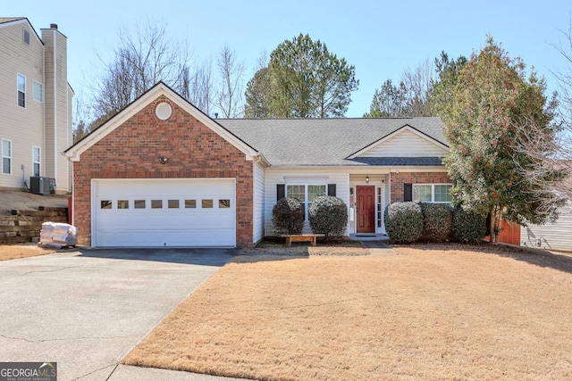 ranch-style home featuring brick siding, a shingled roof, a garage, cooling unit, and driveway