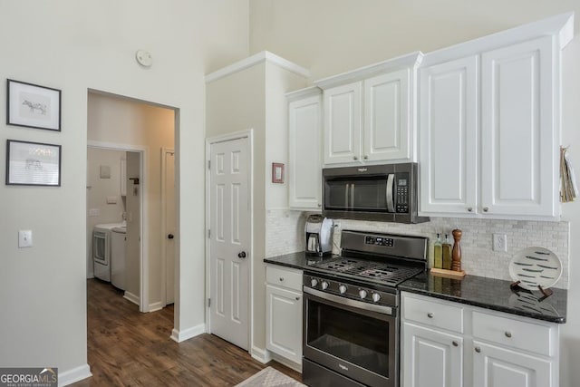 kitchen featuring stainless steel appliances, independent washer and dryer, and white cabinets