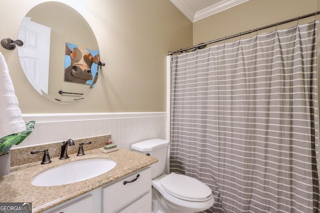 bathroom with a wainscoted wall, ornamental molding, toilet, and vanity