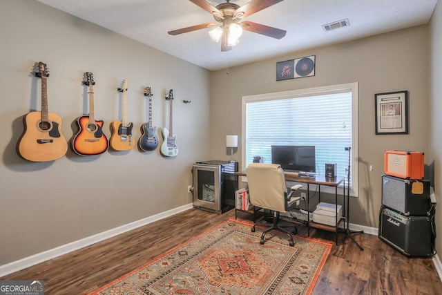 home office featuring baseboards, visible vents, dark wood finished floors, and a ceiling fan