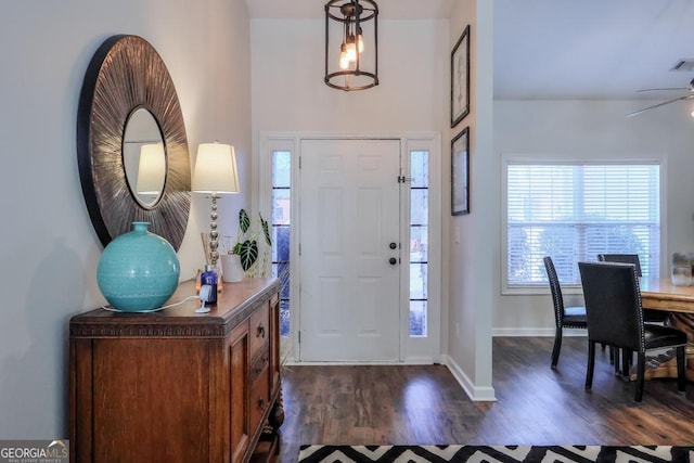 foyer featuring dark wood-type flooring, visible vents, and baseboards