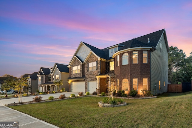 view of front of home featuring an attached garage, brick siding, concrete driveway, stone siding, and a front lawn