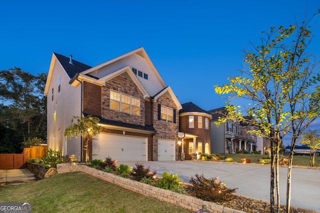 view of front facade featuring a garage, concrete driveway, fence, and stone siding