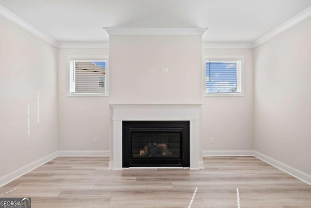 details featuring wood finished floors, ornamental molding, a glass covered fireplace, and baseboards