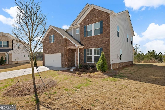 traditional-style home featuring driveway, an attached garage, a front yard, and brick siding