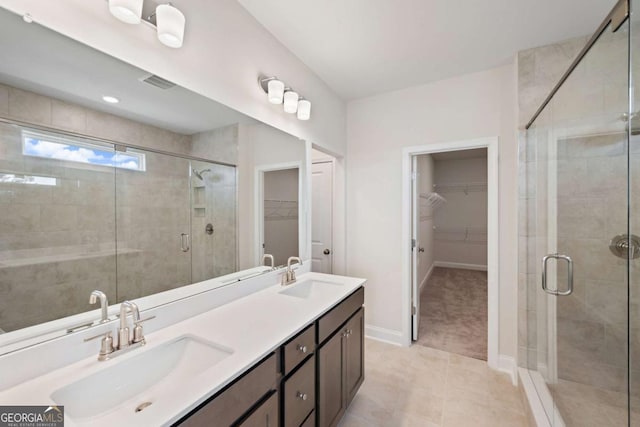 full bath with double vanity, a stall shower, a sink, and visible vents