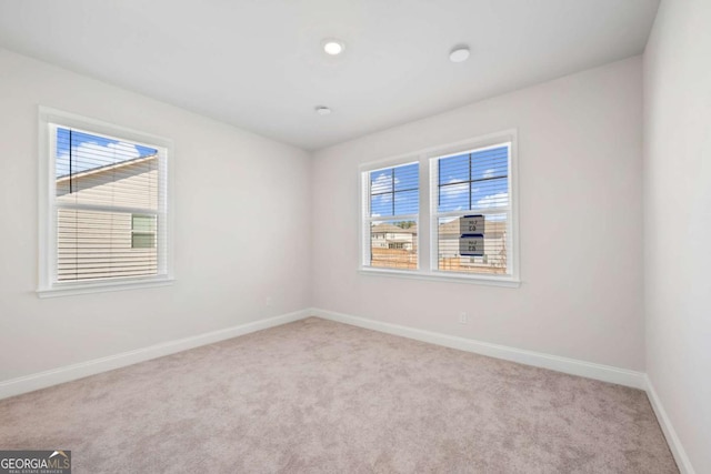 unfurnished room with light carpet, baseboards, and recessed lighting