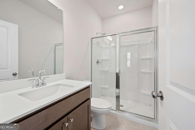 bathroom featuring vanity, a shower stall, toilet, and tile patterned floors