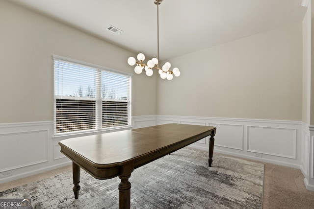 interior space featuring carpet, visible vents, a notable chandelier, and wainscoting