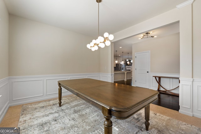 dining room featuring wainscoting and a decorative wall