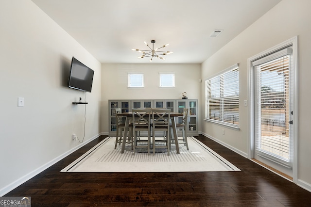 unfurnished dining area with an inviting chandelier, baseboards, and dark wood-style flooring