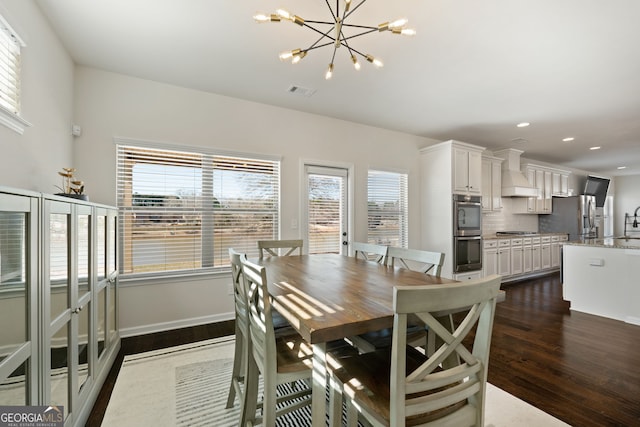 dining room with dark wood-style floors, a notable chandelier, recessed lighting, visible vents, and baseboards