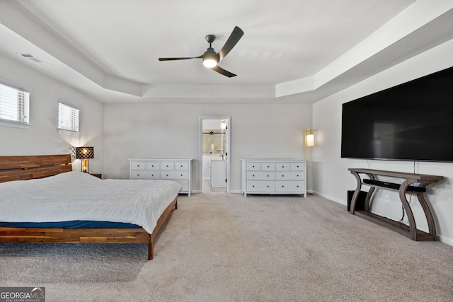 bedroom with light carpet, baseboards, visible vents, and a tray ceiling