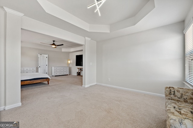 unfurnished bedroom featuring carpet, a raised ceiling, and baseboards