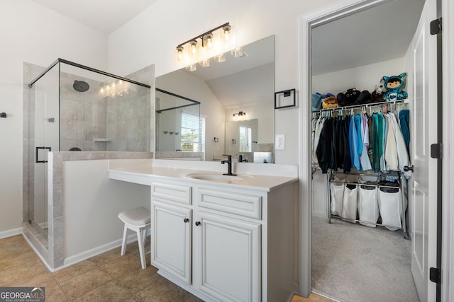 full bathroom featuring a walk in closet, tile patterned flooring, vanity, and a shower stall