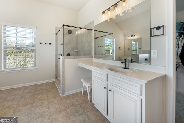 bathroom with a stall shower, a healthy amount of sunlight, vanity, and a spacious closet