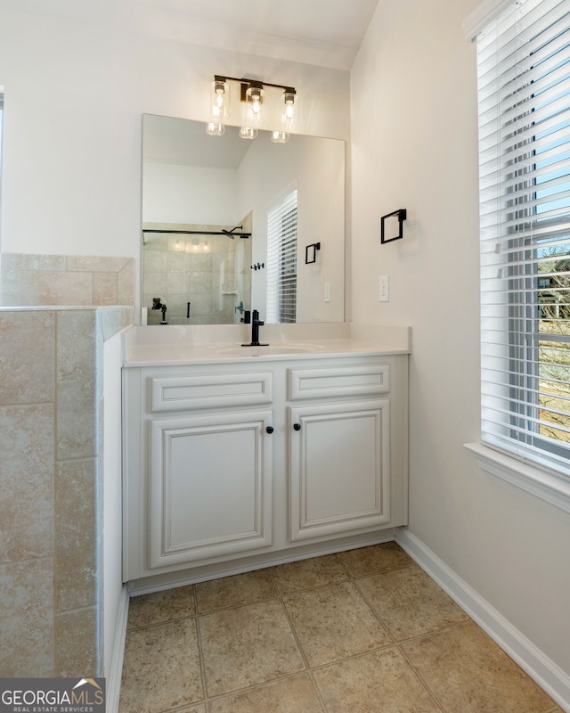 full bath featuring tile patterned flooring, baseboards, a shower stall, and vanity