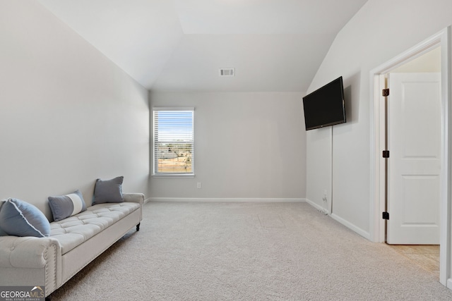 sitting room with light carpet, baseboards, visible vents, and vaulted ceiling