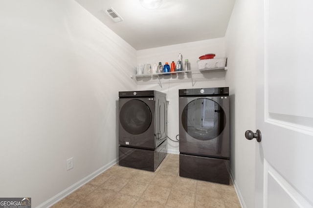 laundry area with laundry area, washing machine and dryer, visible vents, and baseboards