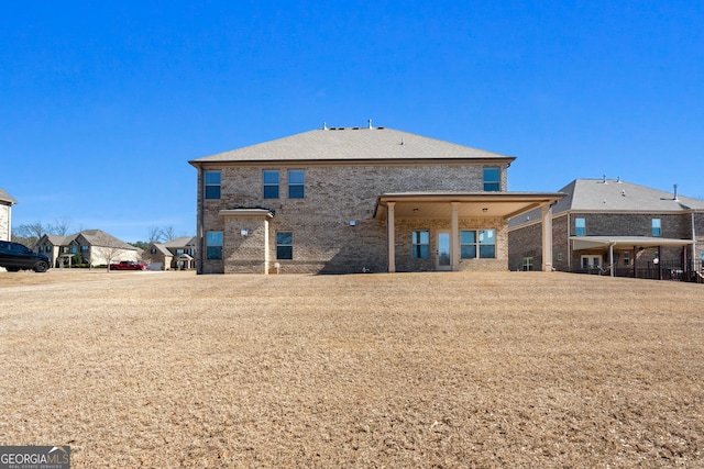 back of property featuring brick siding