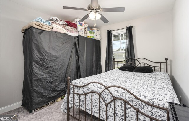 bedroom with a ceiling fan, carpet flooring, and baseboards