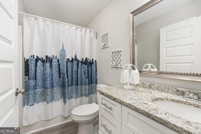 bathroom featuring toilet, wood finished floors, shower / bath combination with curtain, and vanity