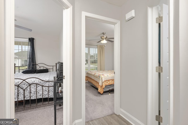 hallway with wood finished floors and baseboards