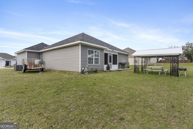rear view of house featuring central AC, a yard, and a gazebo