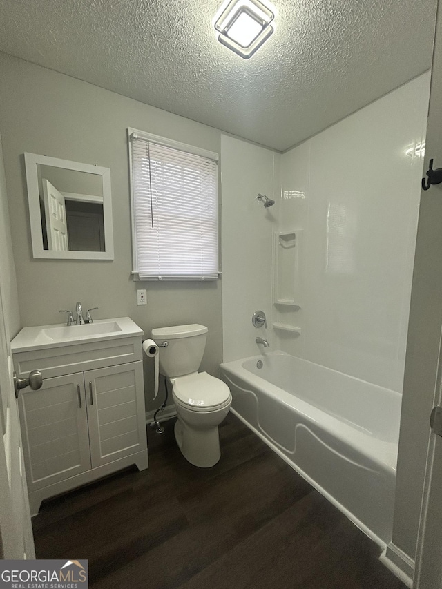 full bathroom with shower / bath combination, toilet, vanity, a textured ceiling, and wood finished floors