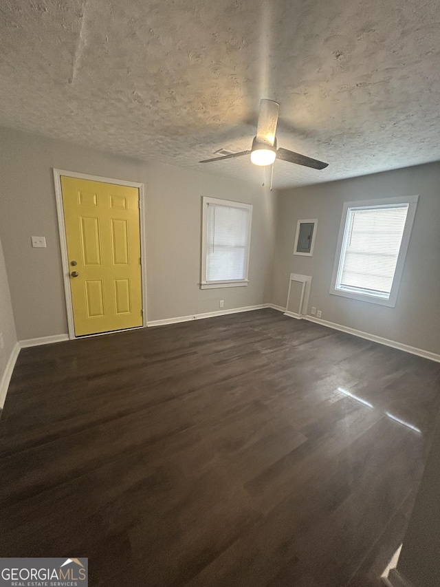 unfurnished room featuring a ceiling fan, dark wood finished floors, a textured ceiling, and baseboards