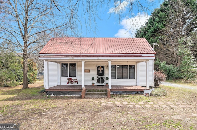 bungalow with ac unit, metal roof, and covered porch