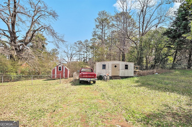 view of yard with entry steps, an outbuilding, a storage unit, and a fenced backyard