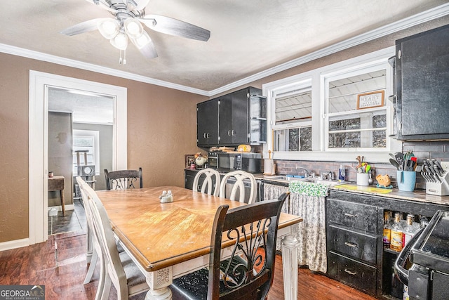 dining space with dark wood finished floors, baseboards, ceiling fan, and crown molding