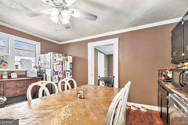 dining room with crown molding, wood finished floors, baseboards, and a textured wall