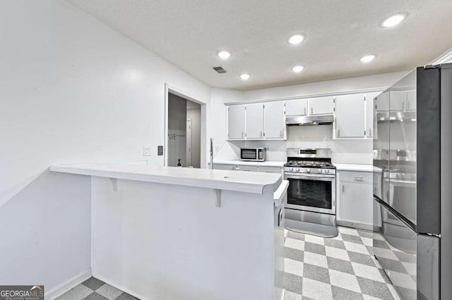 kitchen with light countertops, gas stove, a peninsula, and white cabinets