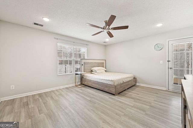 unfurnished bedroom featuring light wood-style floors, access to exterior, visible vents, and baseboards