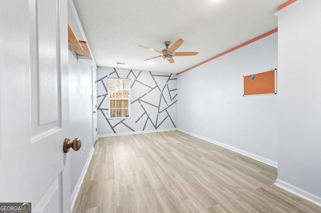 spare room with baseboards, light wood-style flooring, and a ceiling fan