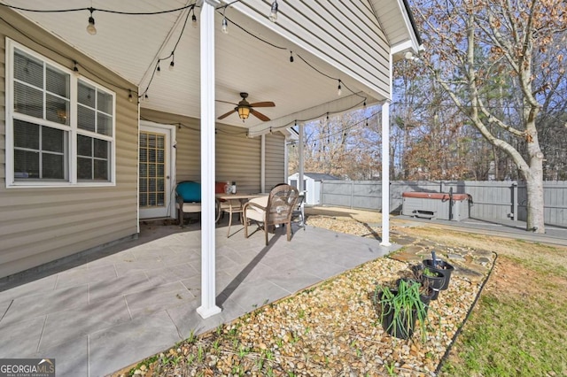 view of patio featuring a hot tub, a ceiling fan, and a fenced backyard