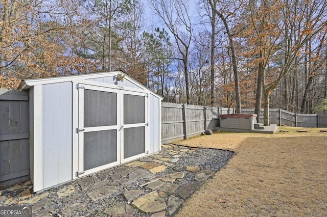 view of shed featuring a hot tub and a fenced backyard