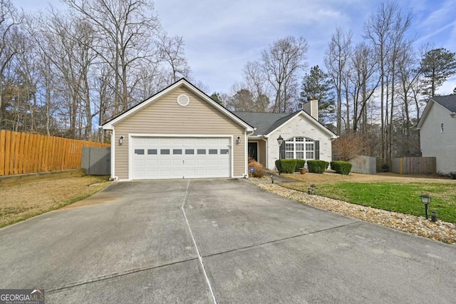 ranch-style house with an attached garage, fence, concrete driveway, a chimney, and a front yard