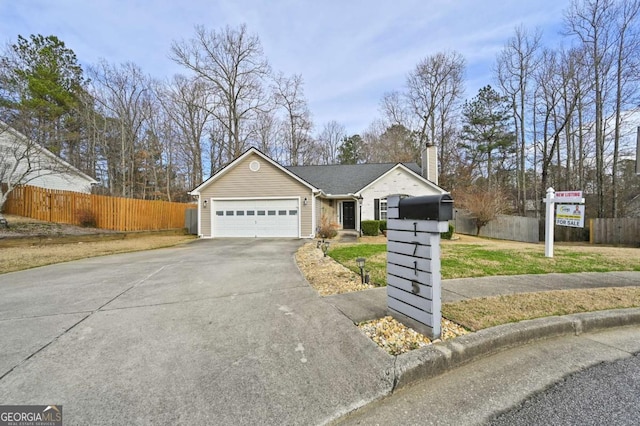 single story home with an attached garage, a chimney, fence, and concrete driveway