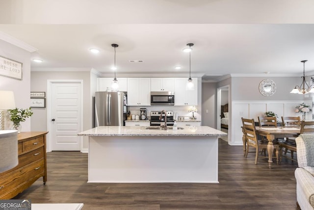 kitchen with appliances with stainless steel finishes, white cabinets, and crown molding