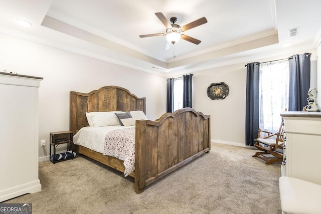 bedroom with visible vents, a tray ceiling, and light colored carpet