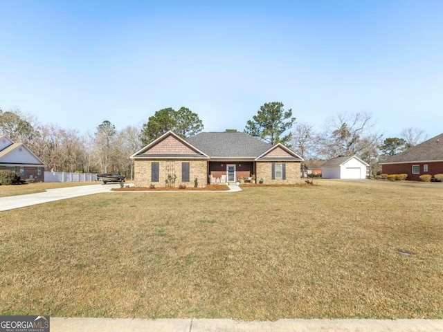 single story home featuring brick siding, an outdoor structure, and a front yard