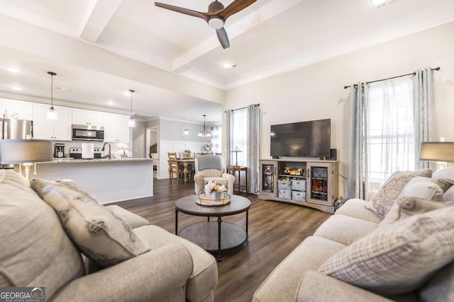 living room with dark wood-type flooring, beamed ceiling, a ceiling fan, and a healthy amount of sunlight