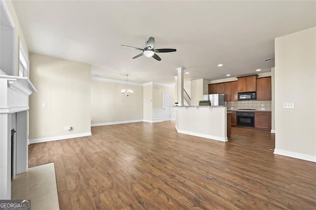 unfurnished living room with a fireplace, recessed lighting, dark wood-type flooring, baseboards, and ceiling fan with notable chandelier