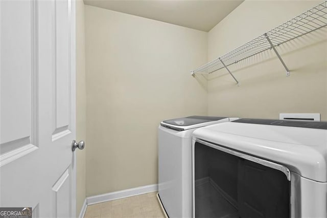 laundry area featuring laundry area, baseboards, and washing machine and clothes dryer